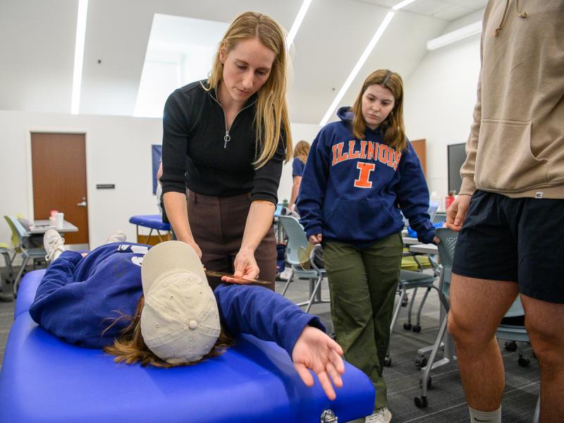 Students doing physical therapy with another student.